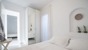 Ein Schlafzimmer mit einem Bett, einem Schreibtisch und einem Spiegel.