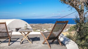 A terrace with two wooden chairs and a small table, overlooking a coastal landscape with a clear view of the sea and distant hills. - Winery Villa. Old winery converted into a stylish traditional villa with pool (Φοινικιά)