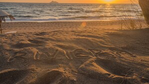 A beach with footprints and the word "RIVIERA" in the sand. - Kalamaki Riviera Deluxe Apartment (Καλαμάκι)