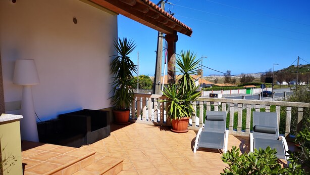 A terrace with a tiled floor, a wooden staircase, two potted plants, a white lamp, and two lounge chairs. - Barrañan Beach Apartments, Apartment 12 (Arteixo)