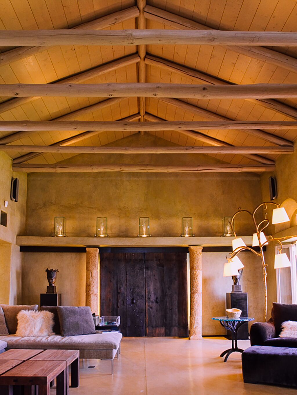 A spacious interior with a high wooden ceiling, a fireplace, and modern furnishings.