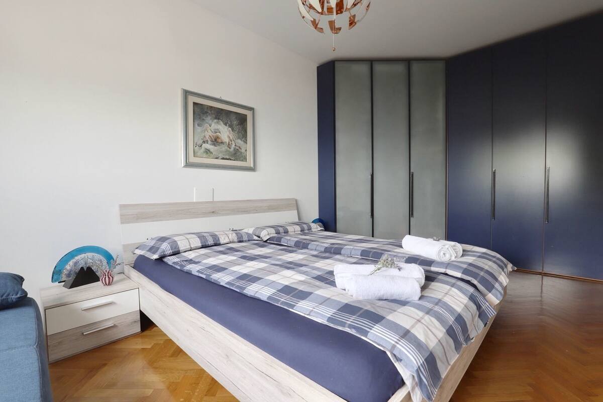 A bedroom with a bed, a nightstand, a dresser, and a wardrobe.