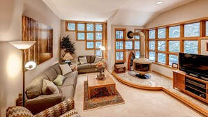 A spacious living room with a large TV, a fireplace, and a cozy seating area.