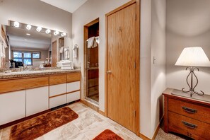 A bathroom with a vanity, mirror, and towel rack. - River Glen Condos by CRMR (Frisco)