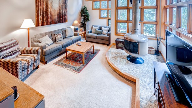 A cozy living room with a fireplace, a sofa, a coffee table, and a television.