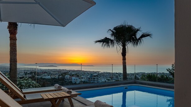 A poolside area with lounge chairs and a view of the sunset over the sea. - Karmilos Hill Villa - close to the center of Chania with private swimming pool. (Χανιά)