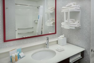 Un baño moderno con un espejo grande, un lavabo blanco y un perchero para toallas.