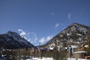 Ein Berggasthaus mit mehreren Hütten, umgeben von schneebedeckten Bäumen und Bergen.