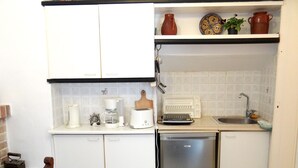 A compact kitchen with white cabinets, a coffee maker, a toaster, a sink, and a dishwasher. - Entire Family Friendly House "Villa Archondisa" in the Old Town (Χανιά)