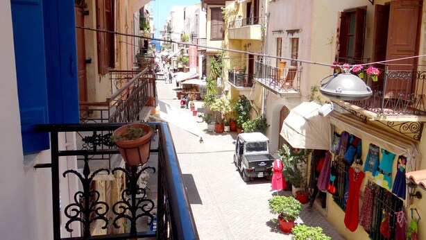 A narrow street with buildings on both sides, balconies with potted plants, and a truck parked on the side. - Entire Family Friendly House "Villa Archondisa" in the Old Town (Χανιά)