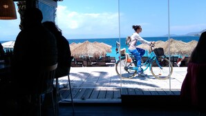 A person riding a bicycle on a wooden deck with a view of the sea and mountains. - Luxury apart. w/ spectacular views (Loutraki-Korinthias)
