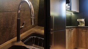 A modern kitchen with a stainless steel refrigerator, a built-in oven, a dishwasher, and a stainless steel faucet. - Atenéo, a modern flat downtown Athens! AMA 00000054917 (Αθήνα)