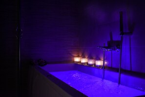 Tina con regadera, tina de hidromasaje, secadora de cabello, toallas 