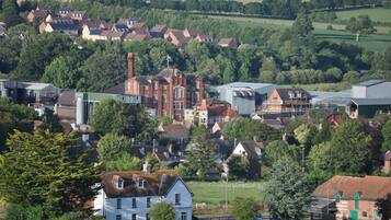 A rural town with a mix of residential and industrial buildings, surrounded by greenery.