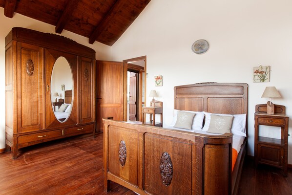 A bedroom with a wooden bed, a dresser, and a mirror. - Luxury stone villa with outdoor jacuzzi, private pool and antique furniture (Πλάκα)