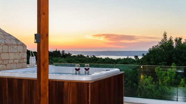 A wooden hot tub with two glasses of red wine on a balcony overlooking a scenic sunset view. - Luxury stone villa with outdoor jacuzzi, private pool and antique furniture (Πλάκα)