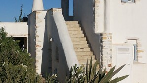 A building with a stone facade, a chimney, and a staircase leading to an upper level. - Villa Petradi (200 meters from the sea)  4 kilometers from Naoussa. (Νάουσα)