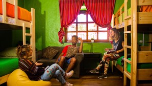 Una habitación con literas, un sofá y un sillón tipo bean bag.