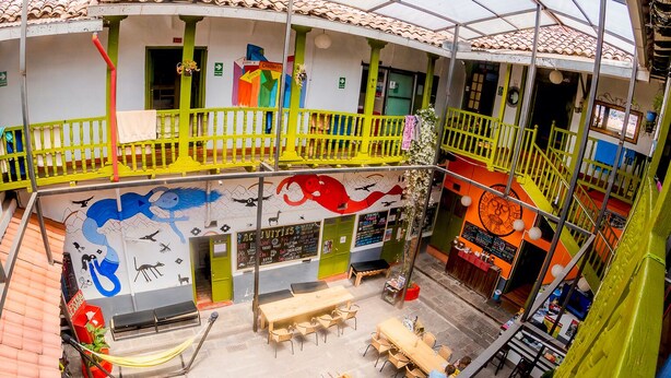 Un espacio interior vibrante con techo alto, varias zonas de estar y una mesa de fútbol de mesa.