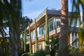 A modern building with a wooden facade, large windows, and a glass balcony.