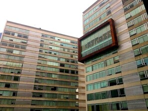 A high-rise building with multiple floors, large windows, and a modern architectural design. - Napoles Condo Suite (Mexico City)