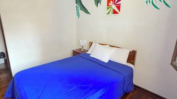 A bedroom with a bed, a nightstand, and a wall mural.