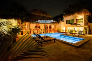 Una piscina al aire libre, sillones reclinables de piscina