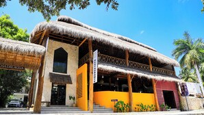 Un bâtiment avec un toit de chaume et une enseigne indiquant « RESTAURANT ».