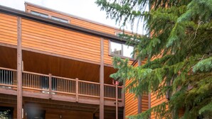 A multi-story building with a stone facade and wooden balconies.