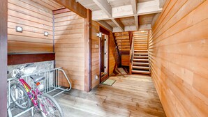 A wooden interior with a bicycle rack and a staircase.