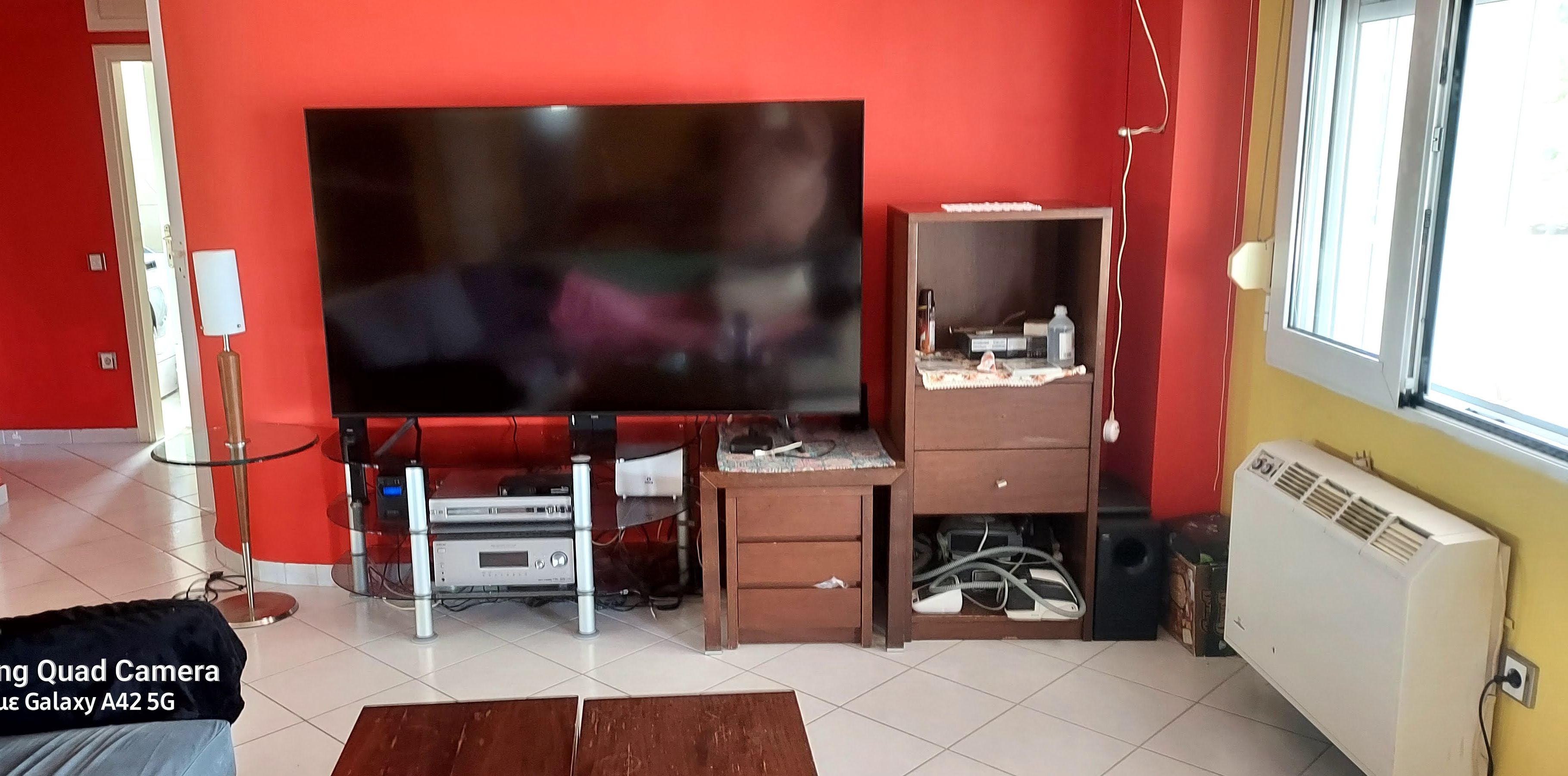 Un salon équipé d’un grand téléviseur à écran plat, d’un meuble en bois et d’un radiateur.
