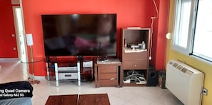 A living room with a large flat-screen TV, a wooden cabinet, and a radiator. - Big house (170m),20m to beach,view to Olympus,near to Thessaloniki airport (Παραλία Επανομής)