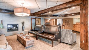 A spacious living room with a leather sofa, a coffee table, and a patterned rug.