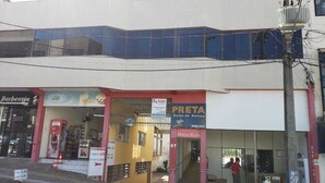 A building with a storefront labeled "PRETA Salão de Beijos" and a visible entrance. - Apartamento Central Setti (Foz do Iguaçu)