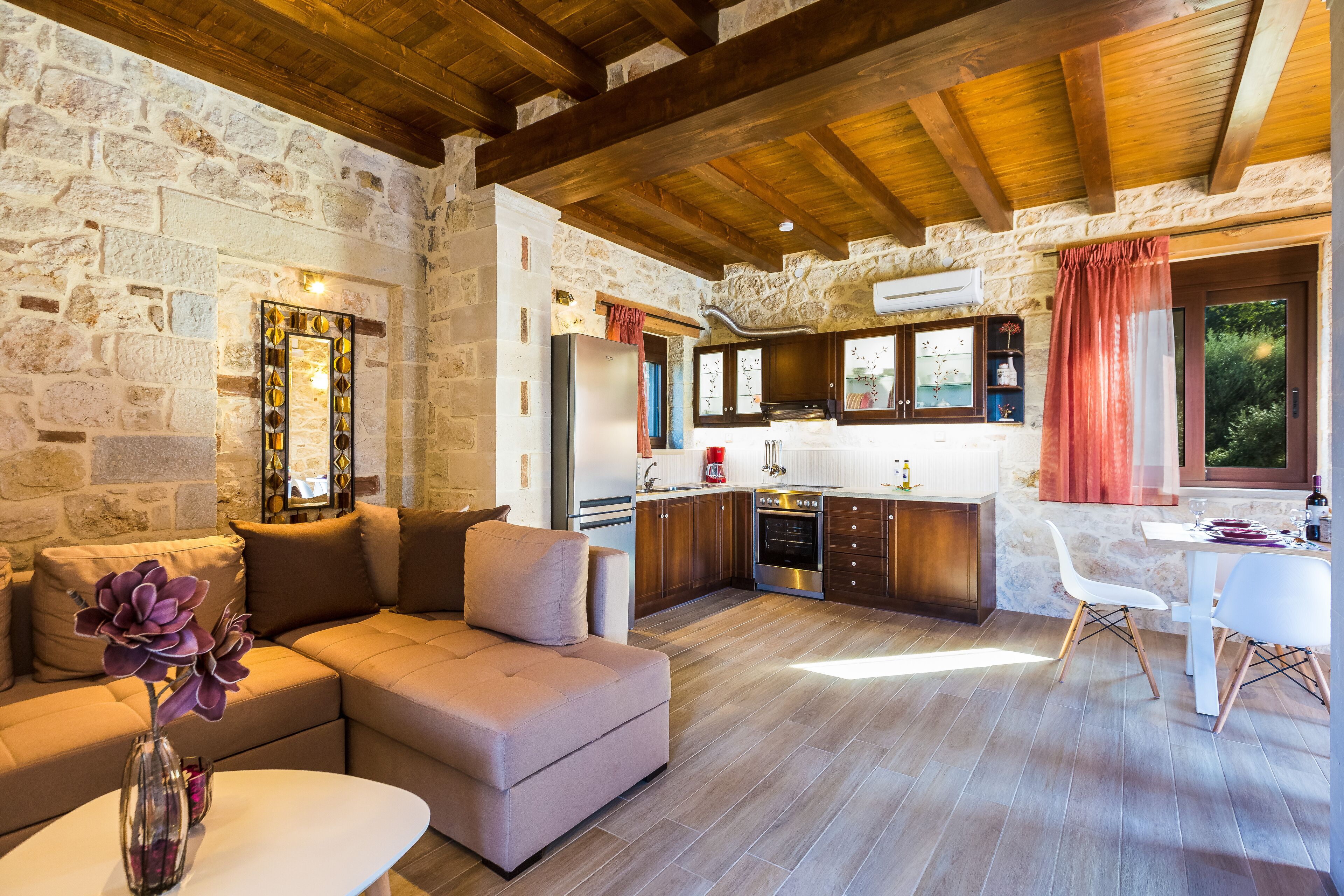 Una sala de estar acogedora con un sofá, una mesa de centro y una pared de piedra.