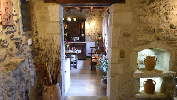 A stone-walled corridor leading to a kitchen with rustic decor, including a wooden ceiling and stone walls. - Crete villa Estia (Ρεθυμνο)