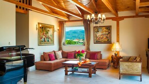A living room with a grand piano, a sofa set, a coffee table, and a view of the outdoors. - Top floor suite near to the town and close to the beach (Lefkada)