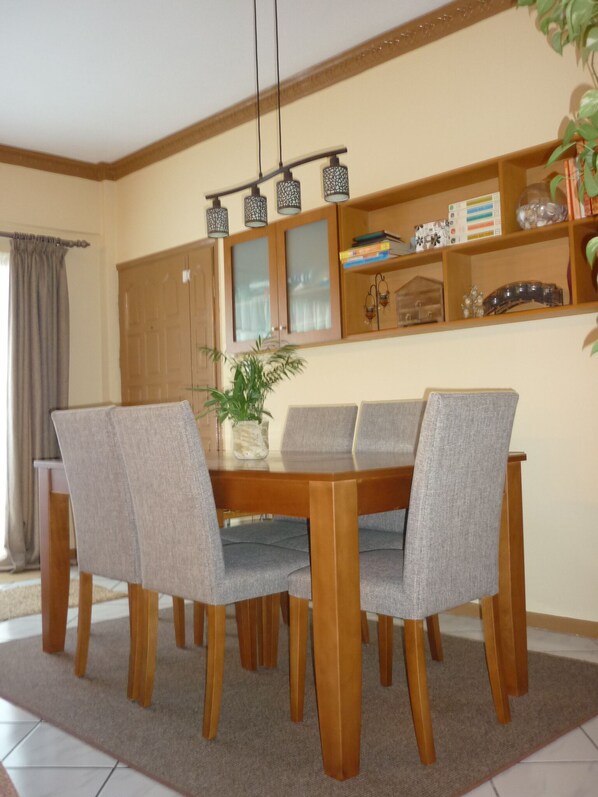Un espace repas avec une table en bois et des chaises à revêtement gris.