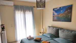 Un dormitorio con dos camas, un cuadro de un lago de montaña, un calentador y una ventana con cortinas.