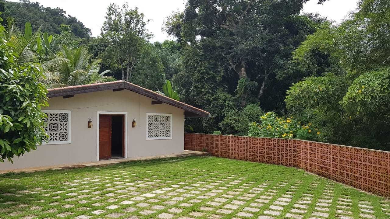 Una casa pequeña con un patio empedrado y una puerta de madera.