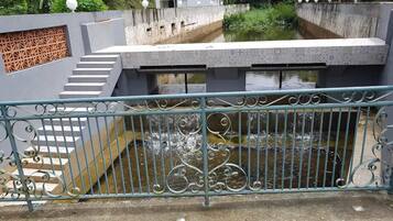 A concrete structure with a metal railing, a staircase, and a water feature.