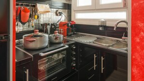 A modern kitchen with black cabinets, red accents, and stainless steel appliances. - ★CENTRAL LUXURY MINI SUITE JULIET★JUST RENOVATED (Θεσσαλονίκη)