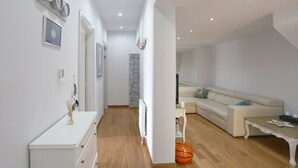Ein modernes Wohnzimmer mit einem weißen Sofa, einem Couchtisch und einem Basketball auf dem Boden.