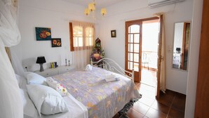 A bedroom with a bed, bedside table, lamp, and a window with curtains. - Villa Karmilos - A family Villa near the cretan sea and the mountains (Sissi)