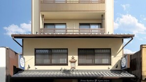Ein mehrstöckiges Gebäude mit flachem Dach, einem Balkon im zweiten Stock und einem Schild, das privates Wohnhaus anzeigt.