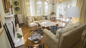 A well-lit living room with a sofa, coffee table, and a fireplace. - Beautiful house close to Thessaloniki (Κύμινα)