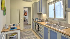 A modern kitchen with grey cabinets, a wooden countertop, and a large window. - Pasmina Home - Stylish & cozy house, Athens, Plaka (Αθήνα)
