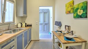 A modern kitchen with stainless steel appliances, a wooden countertop, and a view into the dining area. - Pasmina Home - Stylish & cozy house, Athens, Plaka (Αθήνα)