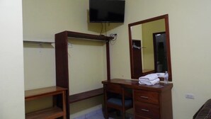 A room with a wooden desk, a chair, a television mounted on the wall, and a mirror above the desk. - Hotel San Cristobal (Guasave)