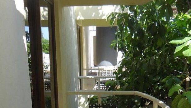 A balcony with a table and chairs, a view of the street, and a door leading to another room. - Hotel San Cristobal (Guasave)